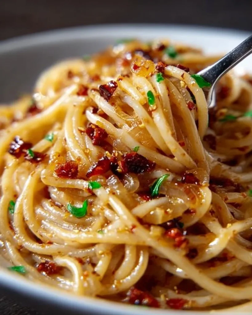 Plate of caramelized onion pasta drizzled with chili oil