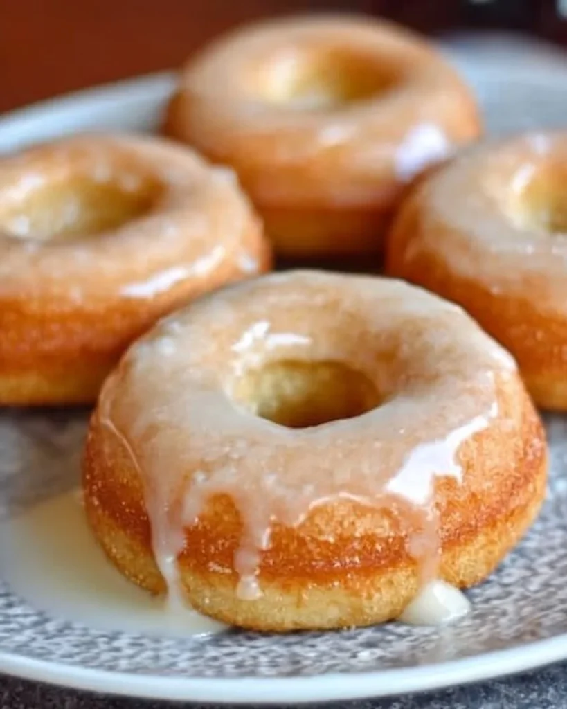 Fluffy baked vanilla donuts topped with icing and sprinkles