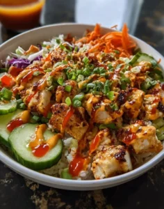 Bang Bang Chicken Bowl served in a colorful dish with fresh vegetables and sauce