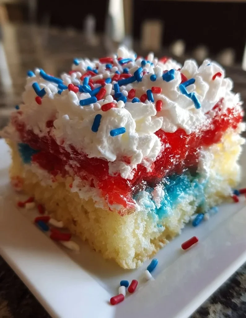 Red, White, & Blue Poke Cake topped with berries and whipped cream.